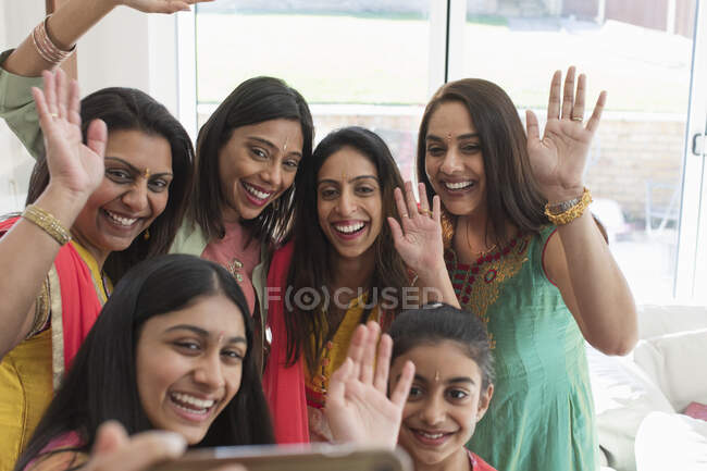 Mujeres y niñas indias felices en saris y bindis tomando selfie - foto de stock