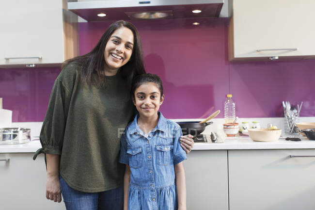 Porträt glückliche indische Mutter und Tochter beim Kochen in der Küche — Stockfoto