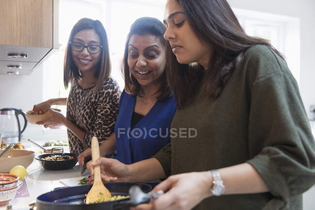 Mulheres indianas felizes cozinhar comida na cozinha — Fotografia de Stock