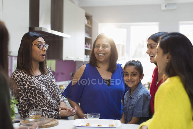 Счастливые индийские женщины и девушки смеются на кухне — стоковое фото