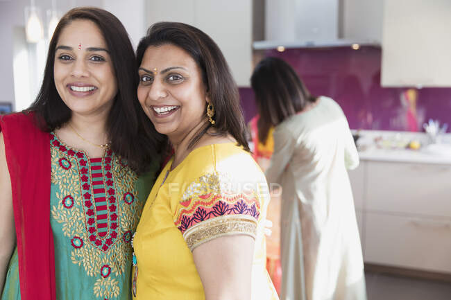 Retrato mujeres indias felices en saris en la cocina - foto de stock