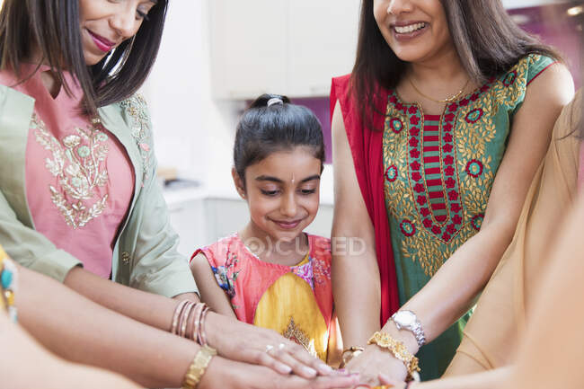Mujeres y niñas indias en saris uniendo sus manos - foto de stock