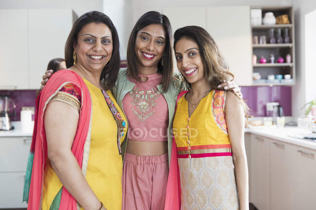 Retrato feliz Irmãs indianas em saris na cozinha — Fotografia de Stock