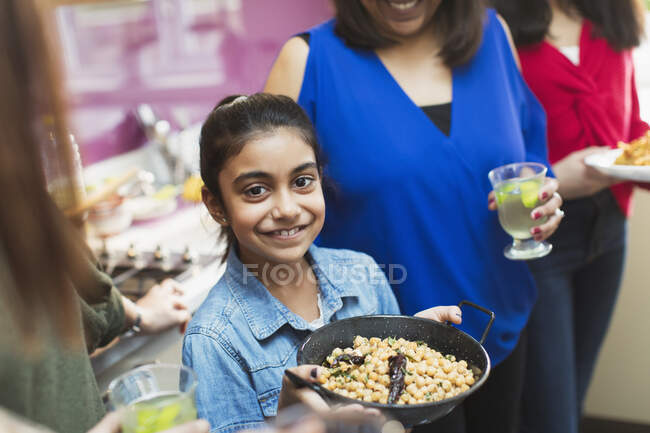 Портрет улыбающаяся индийская девушка готовит еду с семьей на кухне — стоковое фото
