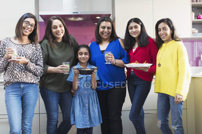 Portrait happy Indian women and girls preparing food in kitchen — Stock Photo