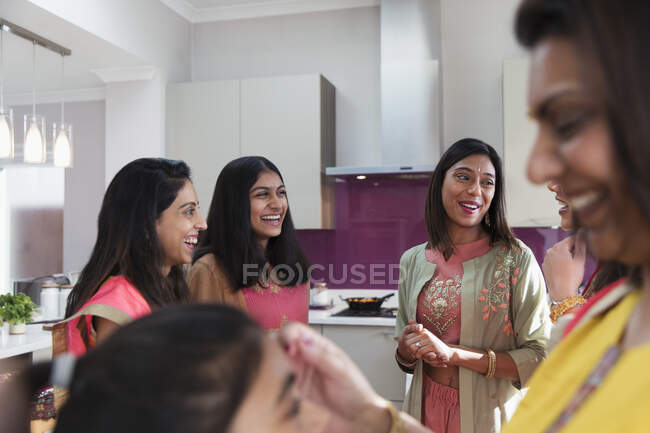 Mulheres indianas felizes em saris falando na cozinha — Fotografia de Stock