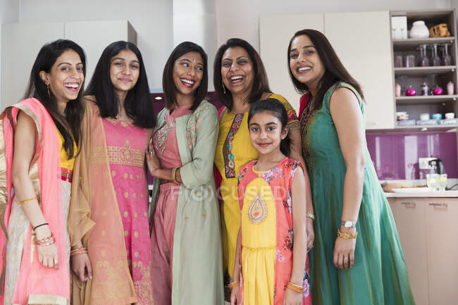Retrato feliz indio mujeres y niñas en saris en la cocina - foto de stock