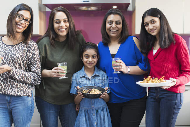 Портрет счастливых индийских женщин и девочек, готовящих еду на кухне — стоковое фото