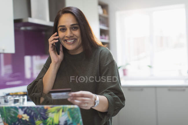 Retrato mulher feliz com telefone inteligente e cartão de crédito no laptop — Fotografia de Stock