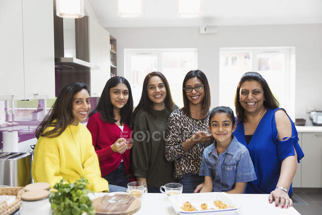 Portrait happy Indian women and girls cooking in kitchen — Stock Photo