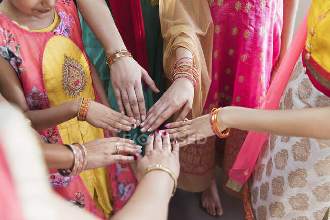 Mujeres indias en saris uniendo sus manos en círculo - foto de stock