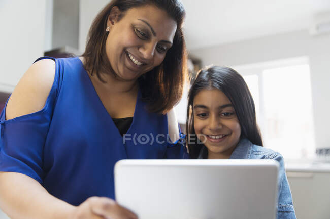 Mère et fille heureuses utilisant une tablette numérique — Photo de stock