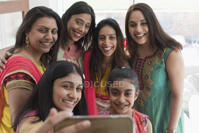 Happy Indian women and girls in saris taking selfie with smart phone — Stock Photo