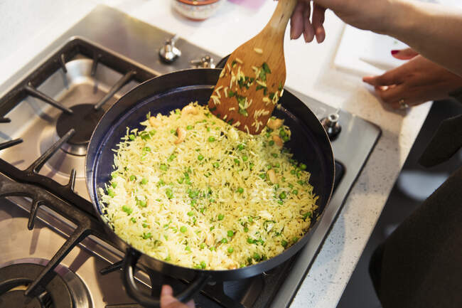 Рис з горохом у сковороді на плиті. — стокове фото