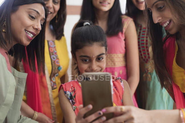 Індійські жінки і дівчата в сарі і бінді використовують смарт-телефон. — стокове фото