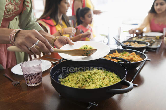 Donne indiane in sari che servono e mangiano cibo a tavola — Foto stock