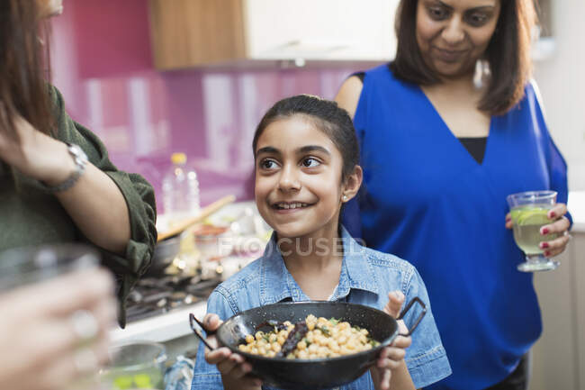 Happy Indian girl with bowl of food in kitchen — Stock Photo