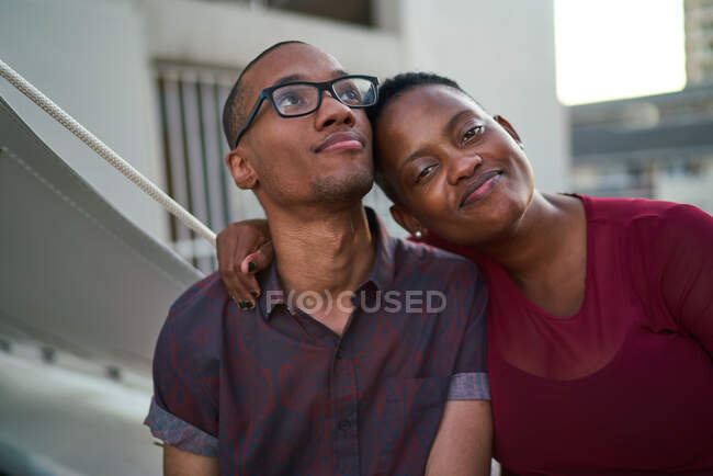 Portrait confiant affectueux jeune couple étreignant sur le patio — Photo de stock