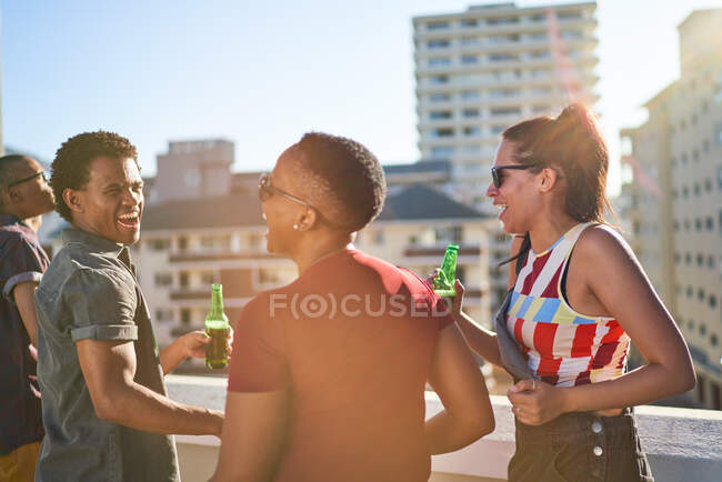 Счастливые молодые друзья болтаются на солнечном городском балконе на крыше — стоковое фото