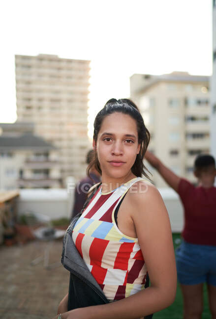 Retrato mujer joven confiada en balcón de la azotea urbana - foto de stock