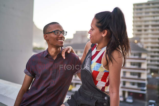 Jovem casal feliz falando na varanda do telhado urbano — Fotografia de Stock