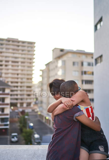 Heureux jeune couple étreignant sur le balcon urbain — Photo de stock