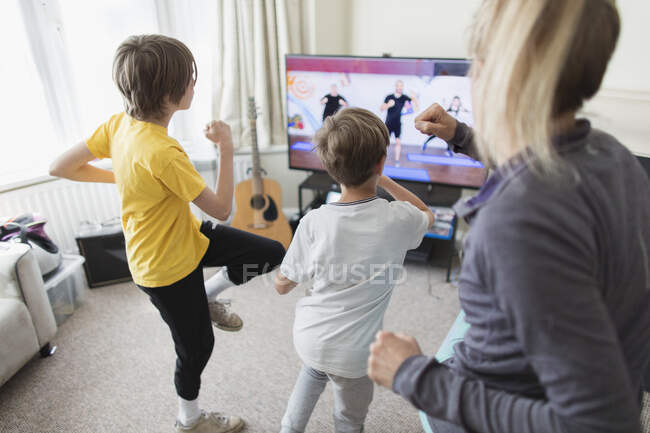 Exercício familiar na TV na sala de estar — Fotografia de Stock