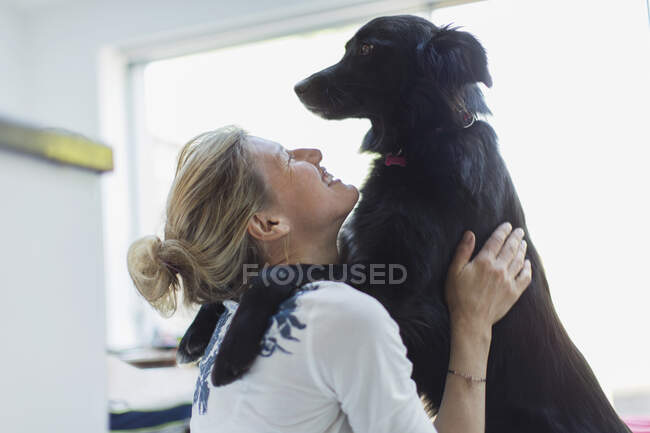 Mujer feliz abrazando perro - foto de stock