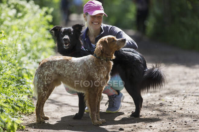 Mujer feliz con perros en ruta de senderismo - foto de stock