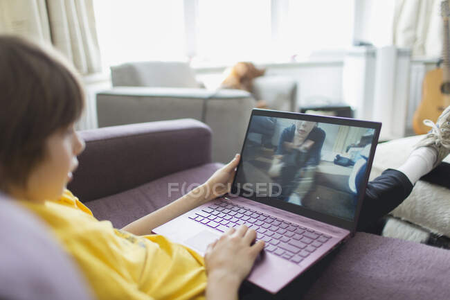 Boy video chatting with friend on laptop — Stock Photo