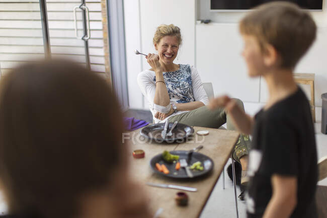 Mãe feliz e filhos almoçando em casa — Fotografia de Stock