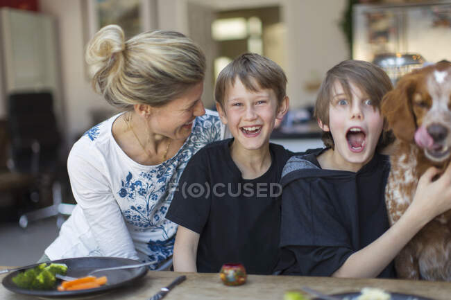Portrait famille heureuse avec chien à table — Photo de stock