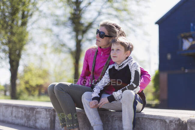 Affectionate mother and son on sunny ledge — Stock Photo