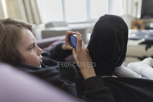 Garçon jouer jeu vidéo avec téléphone intelligent — Photo de stock