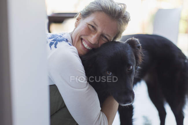 Portrait happy woman hugging dog — Stock Photo