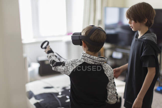 Frères jouant à un jeu vidéo avec des lunettes VRS — Photo de stock