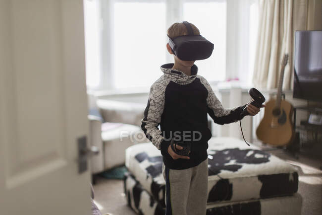 Ragazzo che gioca al videogioco con occhiali VRS in salotto — Foto stock