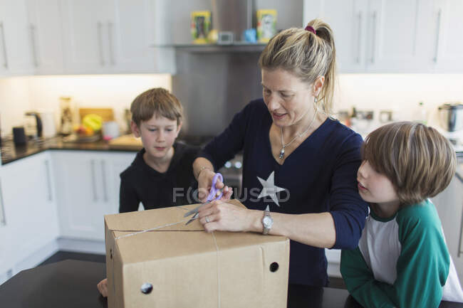 Pacchetto apertura mamma e figli in cucina — Foto stock