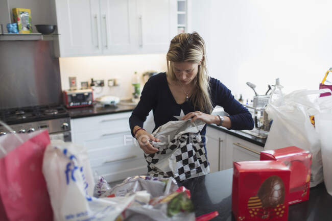 Mulher desembrulhando mantimentos na cozinha — Fotografia de Stock