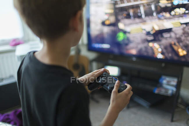 Menino jogando videogame na TV na sala de estar — Fotografia de Stock
