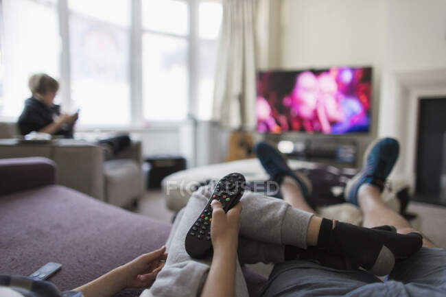 Famiglia POV con telecomando che guarda la TV in soggiorno — Foto stock