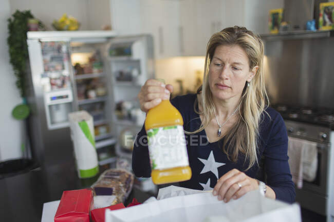 Woman unloading groceries in kitchen — Stock Photo