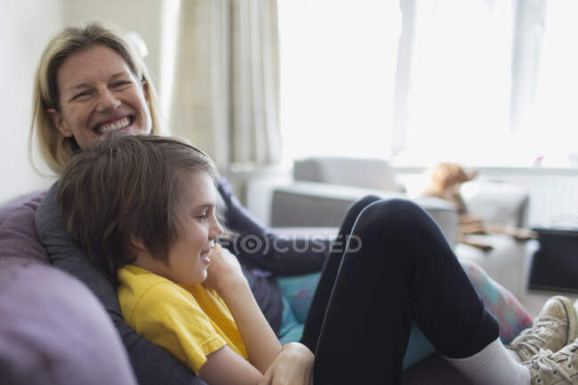 Retrato feliz mãe e filho na sala de estar sofá — Fotografia de Stock