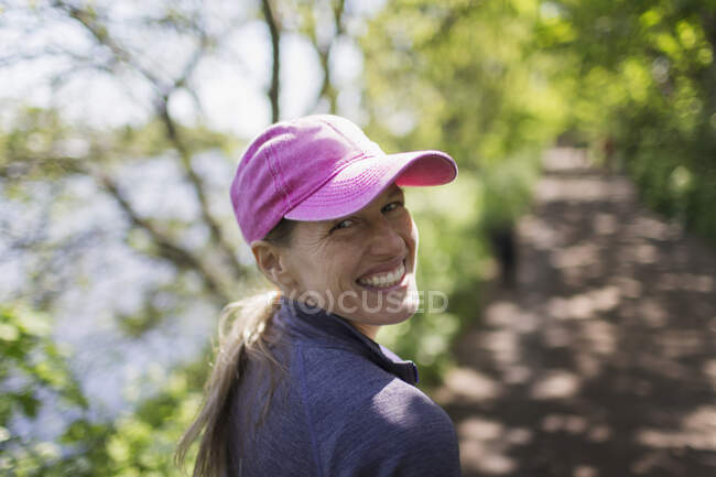 Retrato mujer feliz senderismo en sendero soleado - foto de stock