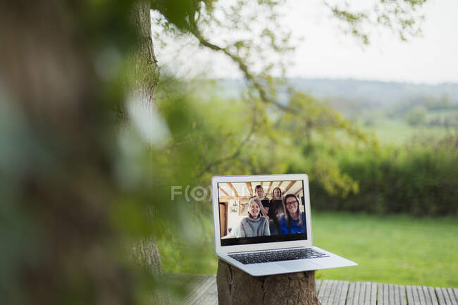 Family video chatting on laptop screen on balcony — Stock Photo