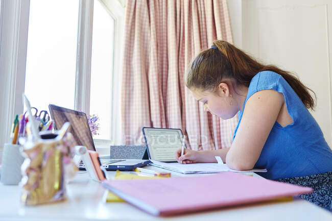 Girl homeschooling at desk in bedroom — Stock Photo