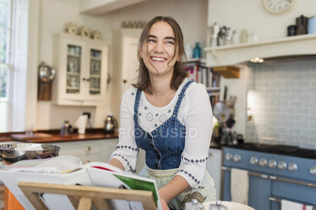 Счастливая девочка-подросток готовит на кухне — стоковое фото
