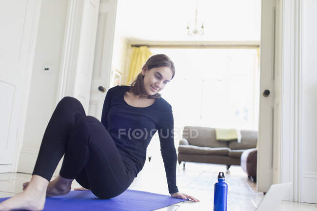 Chica adolescente haciendo ejercicio en línea en casa - foto de stock