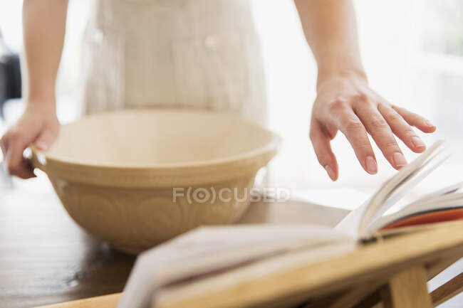 Close up teenage girl baking with cookbook — Stock Photo