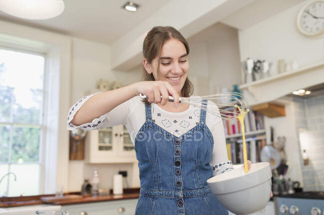 Счастливая девочка-подросток печет на кухне — стоковое фото